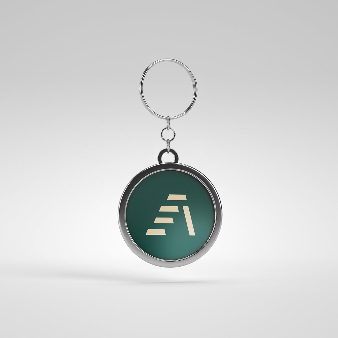 Metal keyring with the Attain mark in green