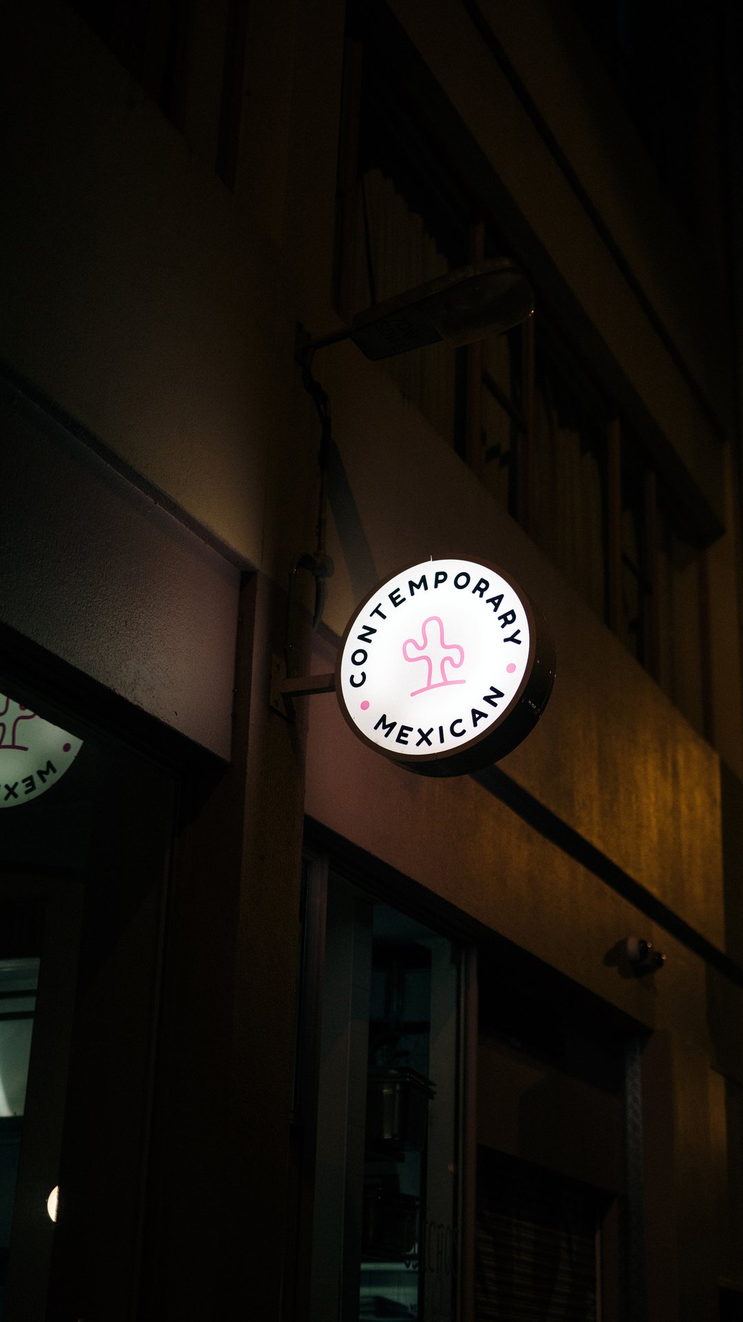 Round Contemporary Mexican blade sign on the Checho’s building at night