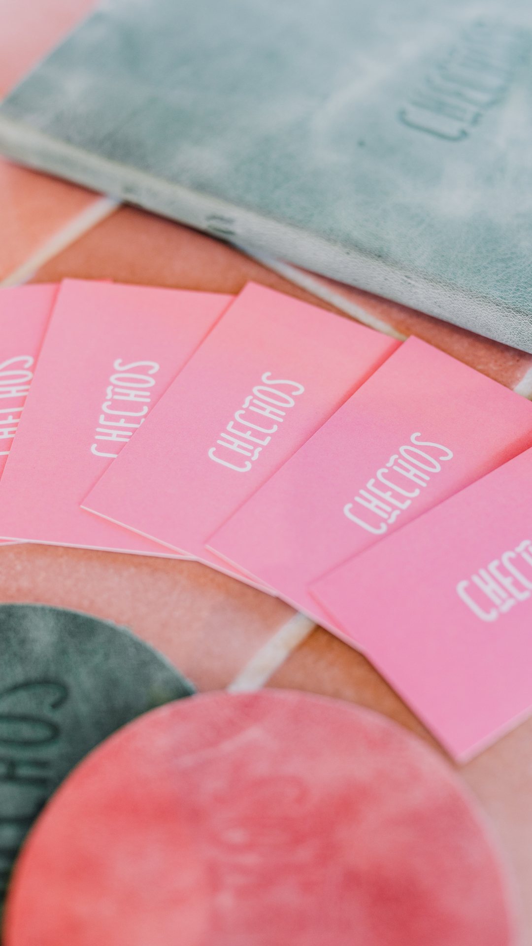 Pink Checho’s cards fanned out on a tiled table